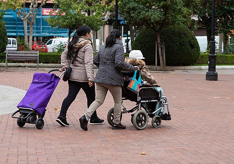 Una mujer en silla de ruedas, ayudada por otras dos, atraviesa el Espolón logroñés