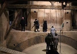 El párroco Carlos Esteban guía, hace unos días, a la alcaldesa y a la presidenta del Parlamento por el pasillo alrededor de la bóveda central.