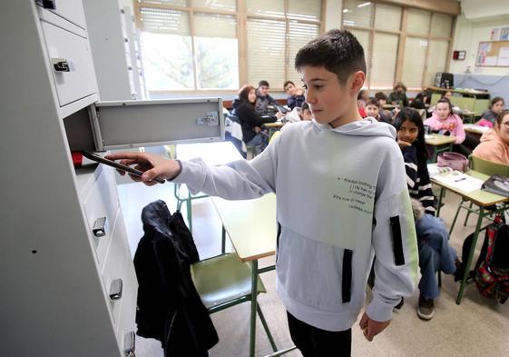 Un alumno del IES Hermanos D'Elhuyar, de Logroño, deposita su teléfono en la taquilla instalada para tal fin.