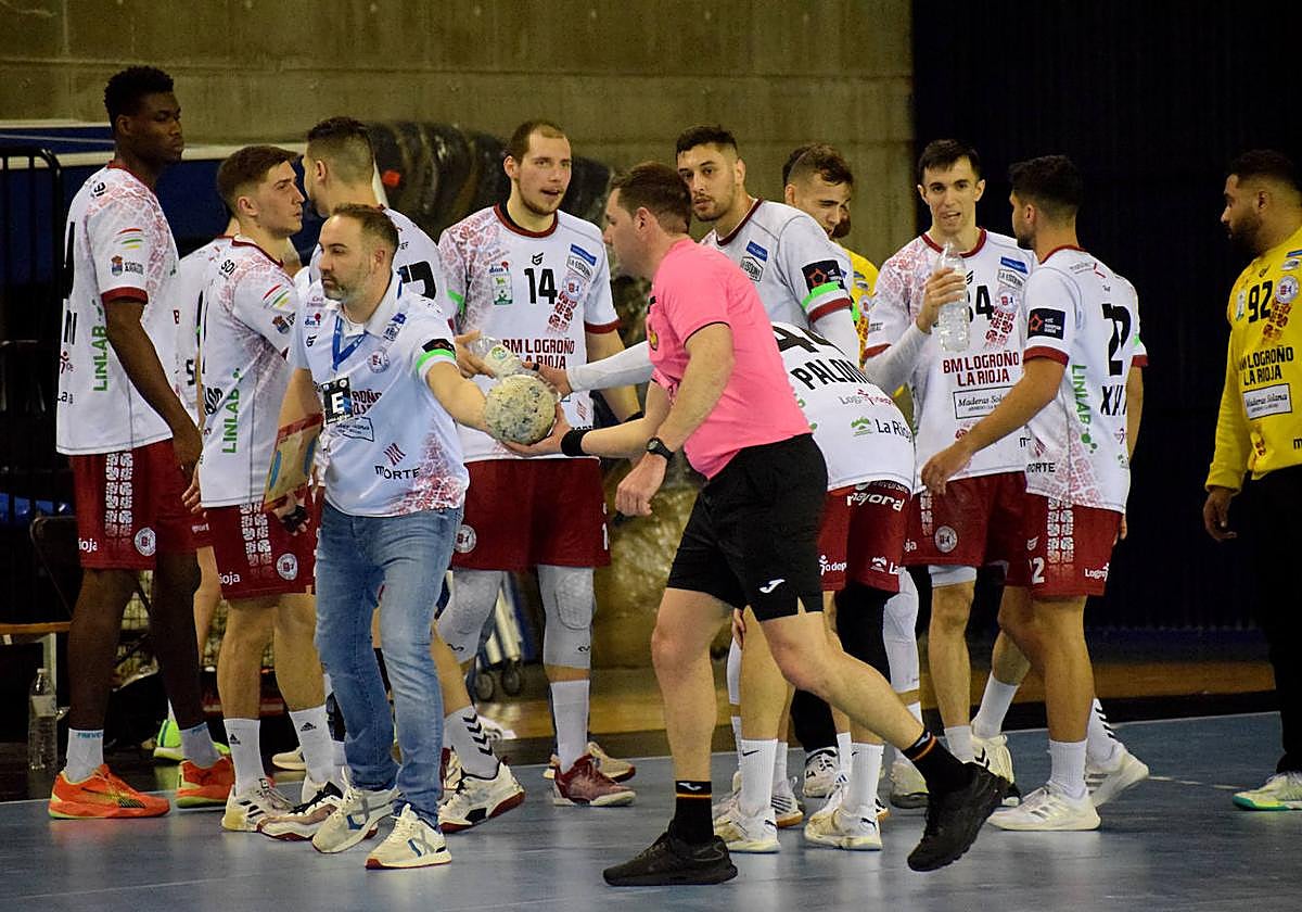 Miguel Velasco entrega el balón a los árbitros en un tiempo muerto.