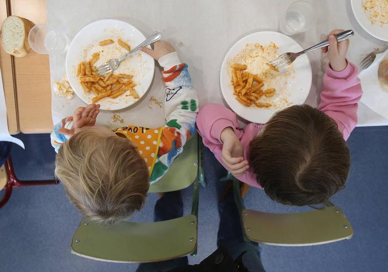 Dos niños, en un comedor escolar.