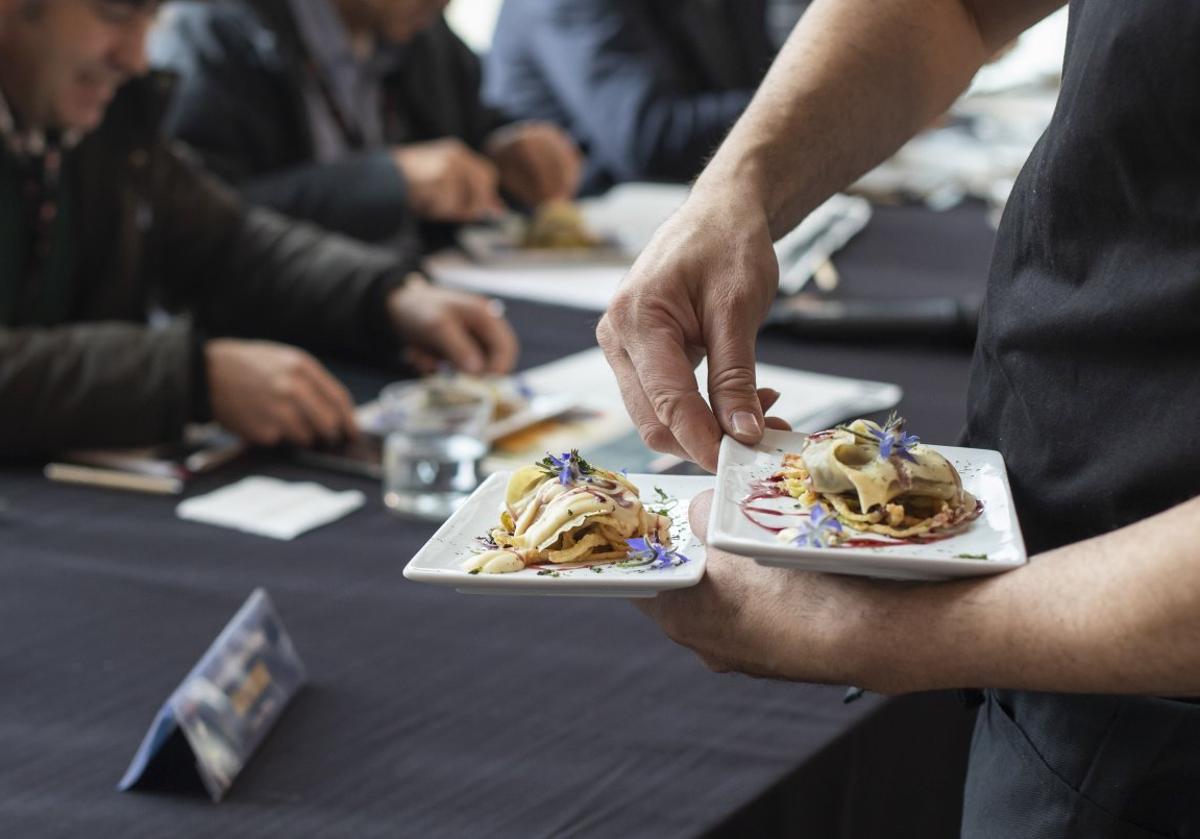 Un camarero lleva ante el jurado de una edición anterior los pinchos elaborados.