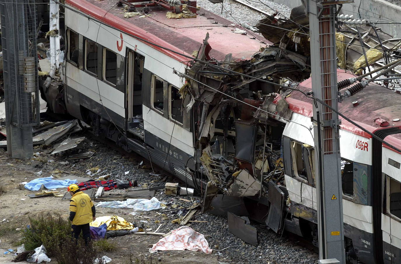 Tren en Atocha destrozado por una de las explosiones, con víctimas en el suelo y un sanitario.