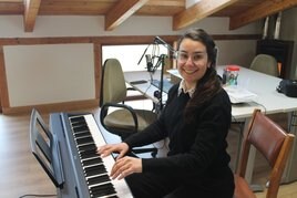 Ayelen Correa posa sonriente, mientras toca de memoria una pieza de música clásica, en el piano que le ha prestado la Asociación ON&OFF.