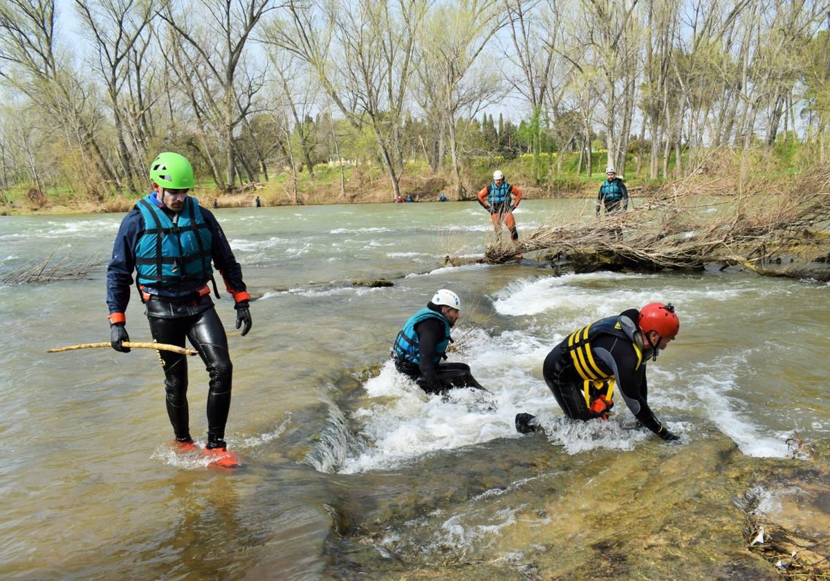 Bomberos voluntarios se adentran en el río Ebro por la zona de la plaza de toros el pasado miércoles, horas antes de su hallazgo.