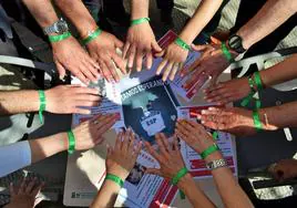 Un grupo de voluntarios muestran sus pulseras verdes.