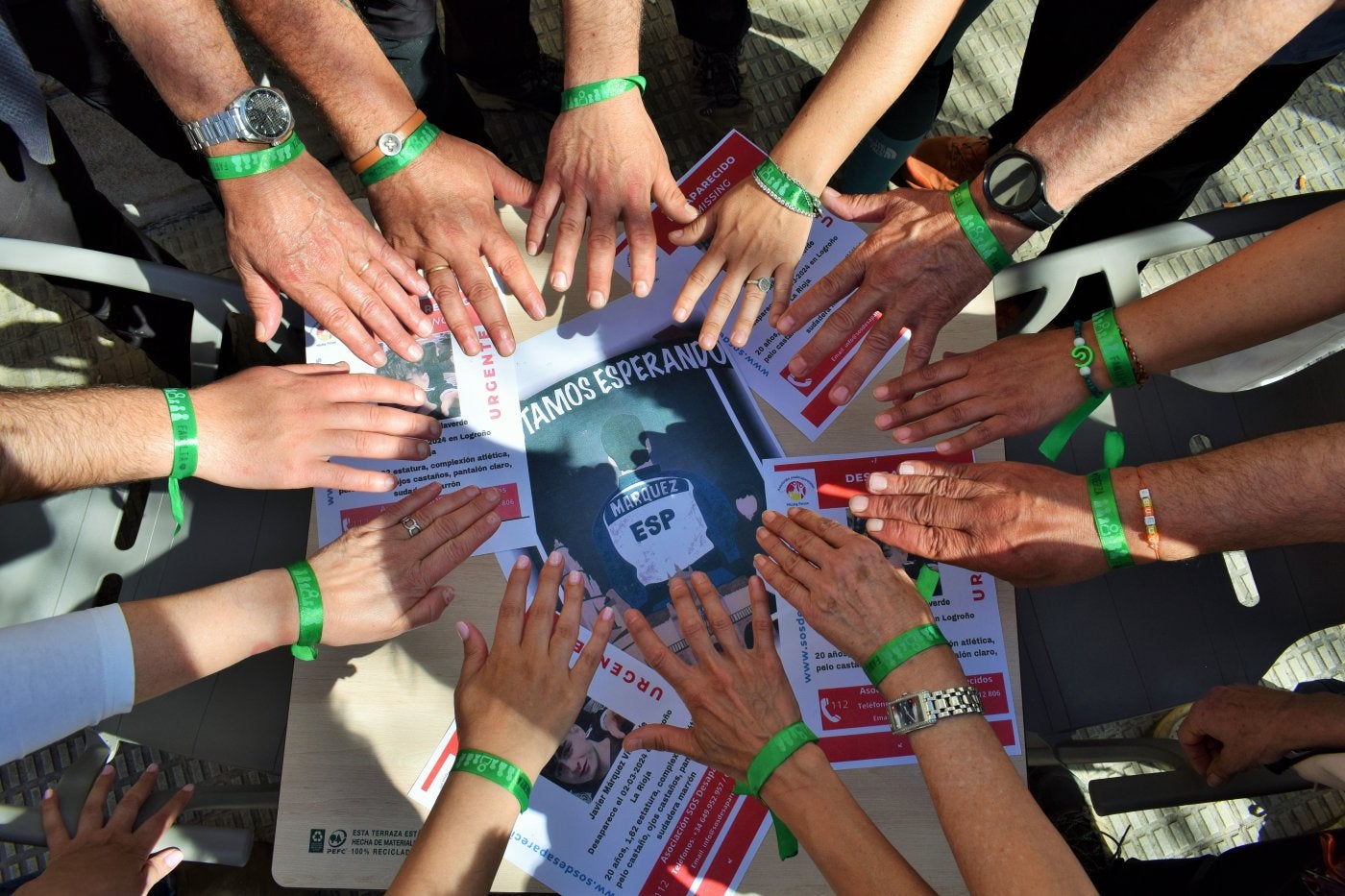 Un grupo de voluntarios muestran sus pulseras verdes.