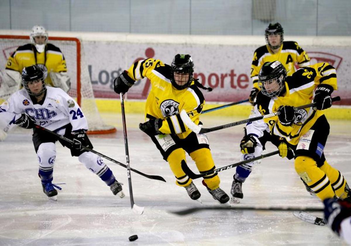 Dos de la campeonas, de amarillo, se llevan el puck