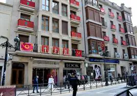 Un agente de la Policía, este miércoles en el mercadillo, delante de un edificio de la calle Mártires decorado con balconadas de la Vera Cruz y Paso Viviente.