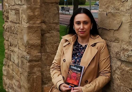 Silvia Eguíluz González posa en unas ruinas de Logroño con su libro.