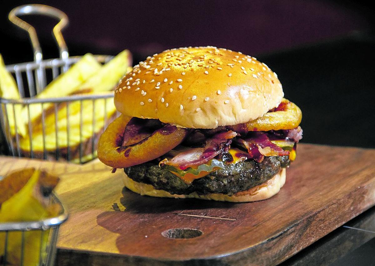 Imagen secundaria 1 - Arriba una hamburguesa con mucho queso; debajo, una más clásica con aros de cebolla y una típica hamburguesa de una cadena multinacional de comida rápida