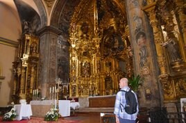 Un turista, ayer lunes, delante del retablo del altar mayor de la iglesia de Santiago.