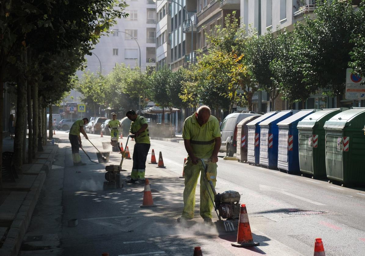 Cuatro operarios desmantelan el carril de avenida de Portugal.