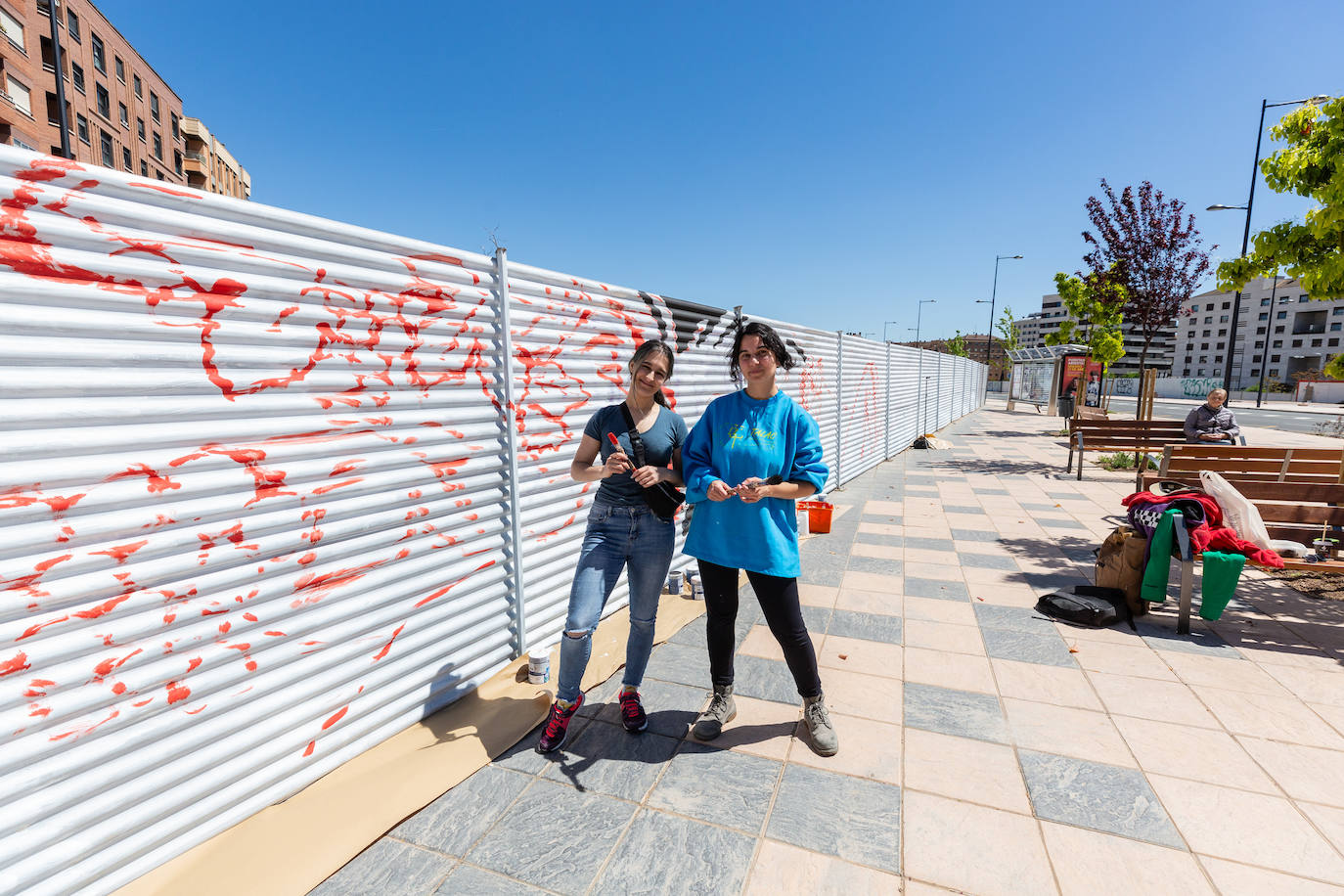 Las jóvenes artistas locales posan junto al 'lienzo' que deja ver sus primeros trazos.