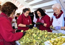 Peñistas del Hambre, pelando alcachofas para la degustación de las peñas en los bajos de la plaza de toros.