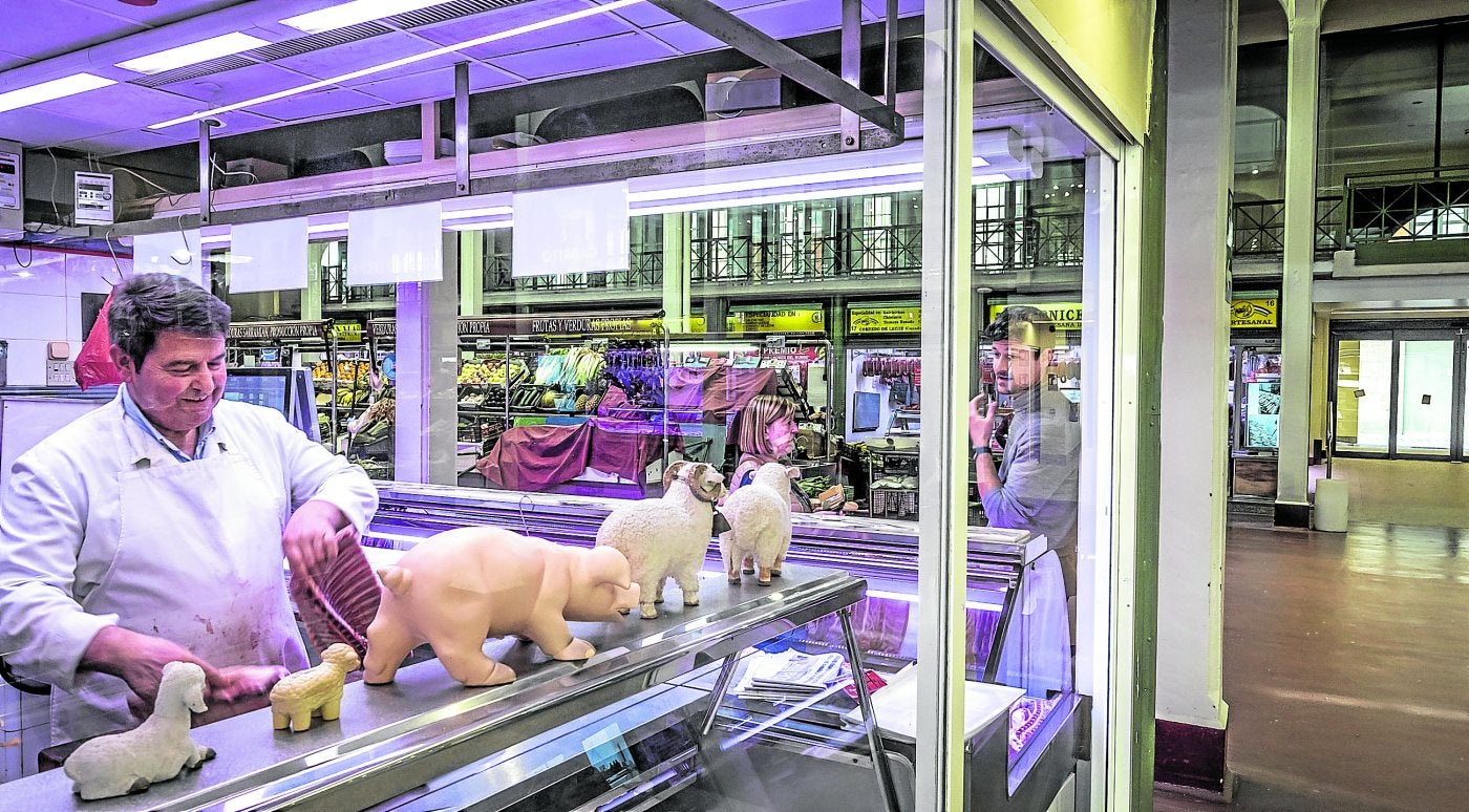 Luis Terroba, uno de los comerciantes de la plaza, trabajando en su carnicería.
