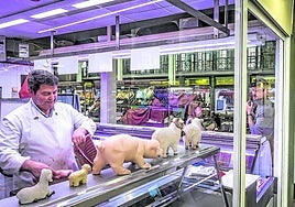 Luis Terroba, uno de los comerciantes de la plaza, trabajando en su carnicería.