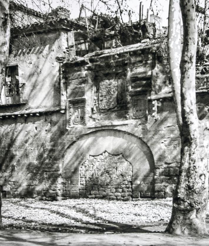 Imagen secundaria 2 - Imágenes en blanco y negro expuestas en el propio complejo a día de hoy, siendo entonces el 'Cinema Frontón' (con la colocación de una balaustrada en los años 30 como parte de la terraza), y la Puerta del Camino (o de Carlos V) anexa tapiada; y ya en color, parte de los nuevos contenidos con que se actualizó el conjunto de cara al V Centenario del Sitio de 2021.