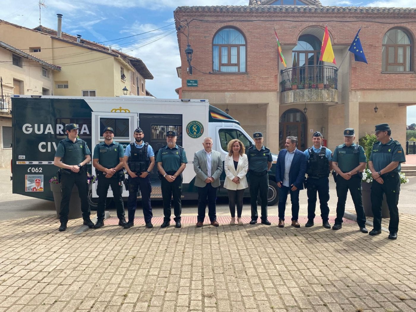 Autoridades civiles y policiales posan delante del vehículo que servirá como nuevo punto de atención para la ciudadanía rural.