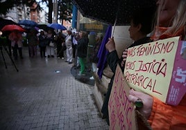Participantes en la concentración, protegidos bajo paraguas.