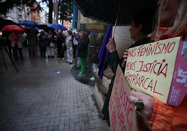Participantes en la concentración, protegidos bajo paraguas.