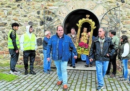 Simón Amuchastegui, a la izquierda, ayuda a sacar la imagen de la Virgen de la Luz de su ermita para la misa celebrada en la Venta de Piqueras.