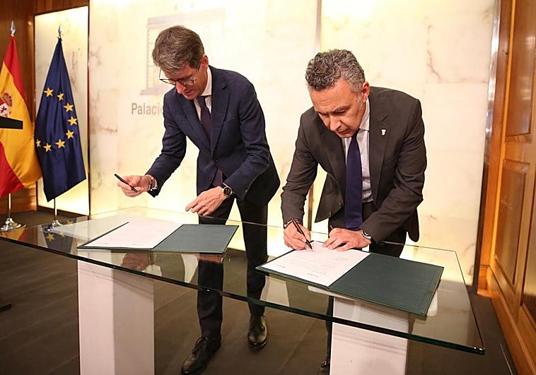 Capellán y Conrado, durante la firma.