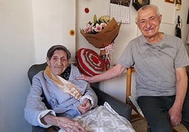 Juana González posa con su banda de feliz cumpleaños, un ramo de flores y su hijo, Carlos Ágreda.