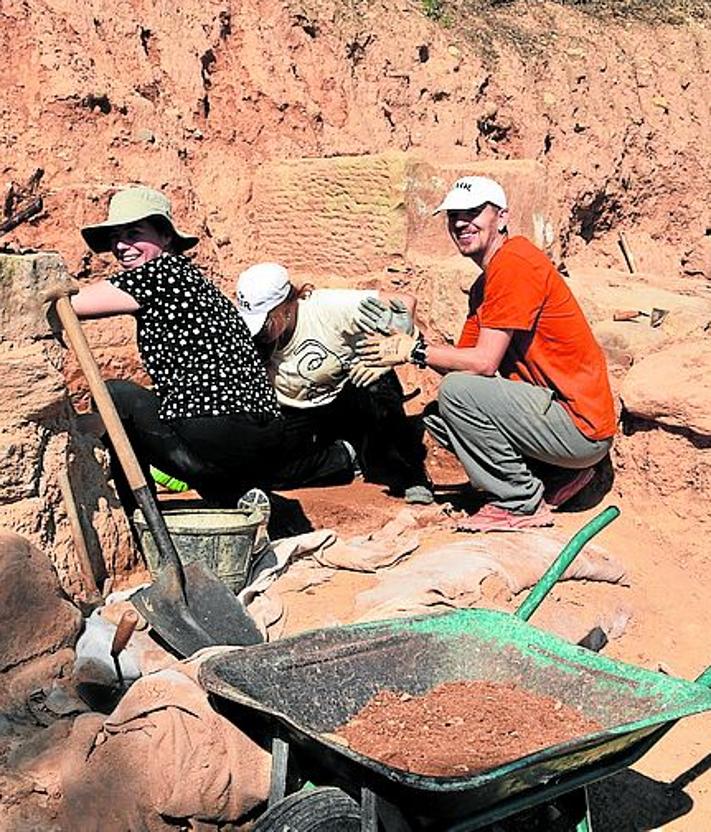 Imagen secundaria 2 - Labores de limpieza en la necrópolis y retirada de tierra y piedras en la excavación de La Clínica(Izq.). Alumnos junto a los restos de estructuras de época romana. 