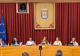 El escudo de 1523, con una corona abierta, preside el salón de plenos.