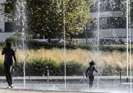 Unas niñas se divierten con los chorros de agua de la fuente del parque Felipe VI de Logroño.