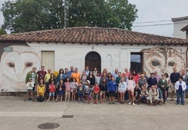 El grupo de vecinos participantes junto a dos murales.