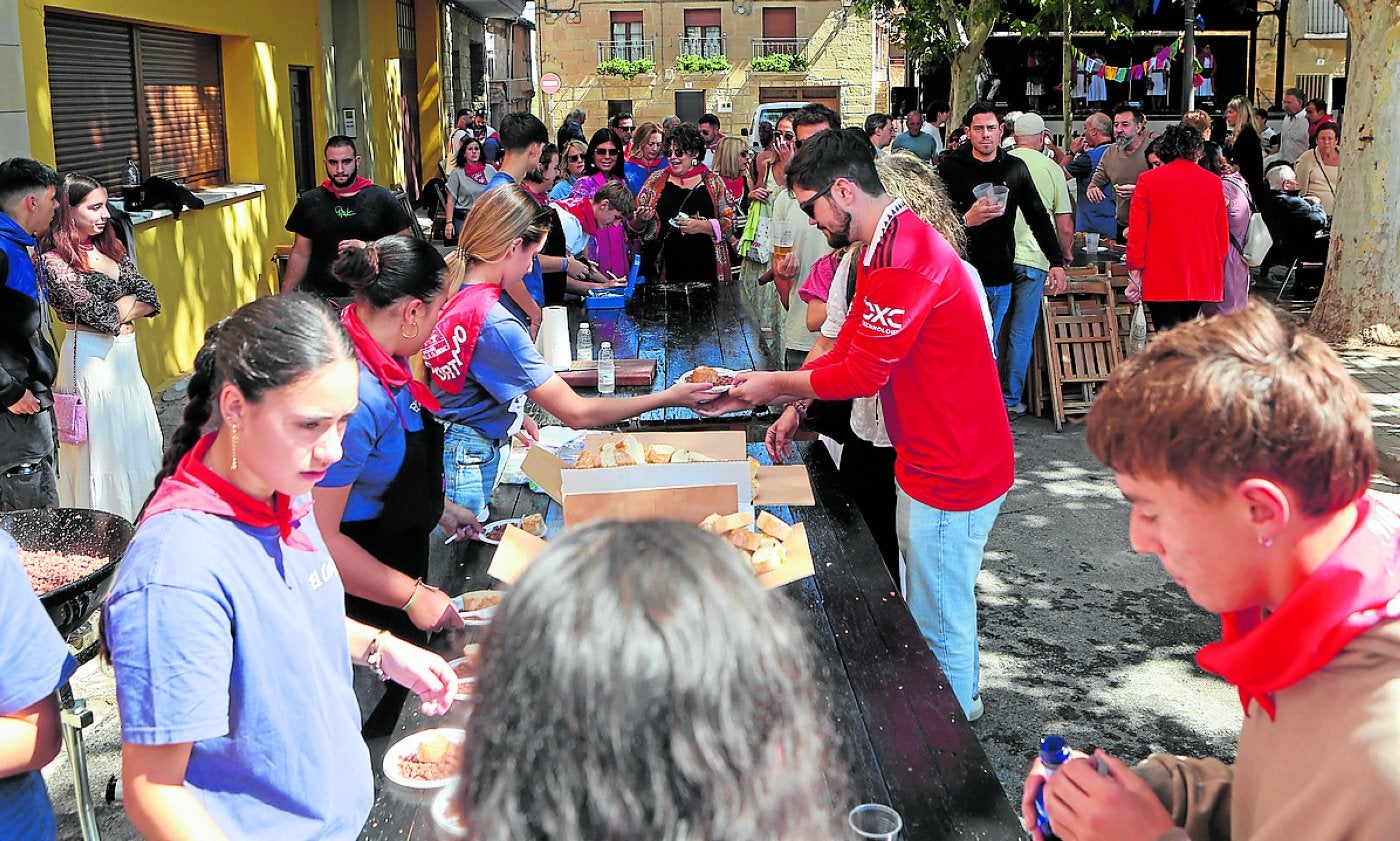 El sol ilumina El Cortijo y los vecinos se alinean para la degustación.