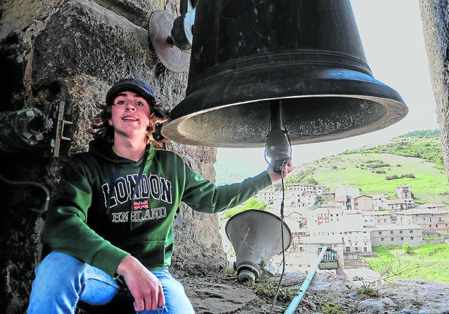 El joven campanero burgalés Ulises Hernando Chico posa con una de las campanas de la iglesia de Nuestra Señora del Sagrario de Villoslada.