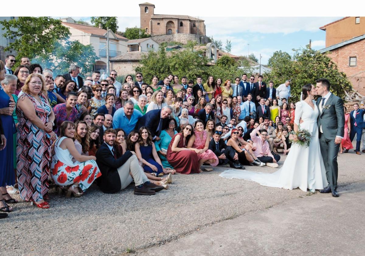 Los novios se besan acompañados por invitados y vecinos tras la ceremonia celebrada en la iglesia parroquial de San Martín.