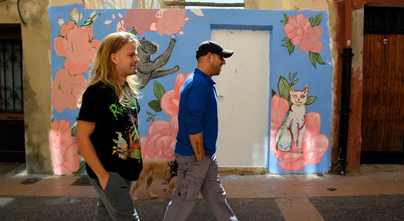 Dos personas pasan por delante de una pintura realizada en la calle Santiago.