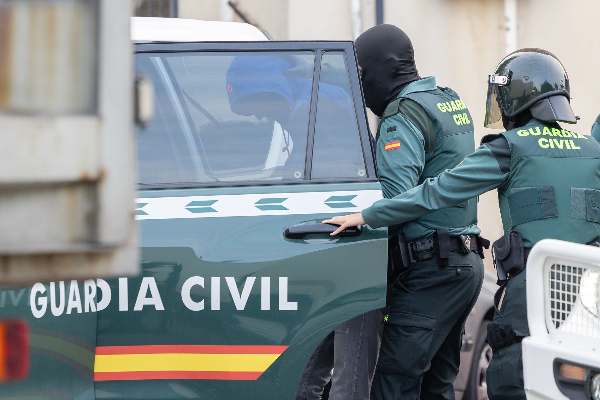 Los agentes se llevan a uno de los detenidos en la calle Ebro.