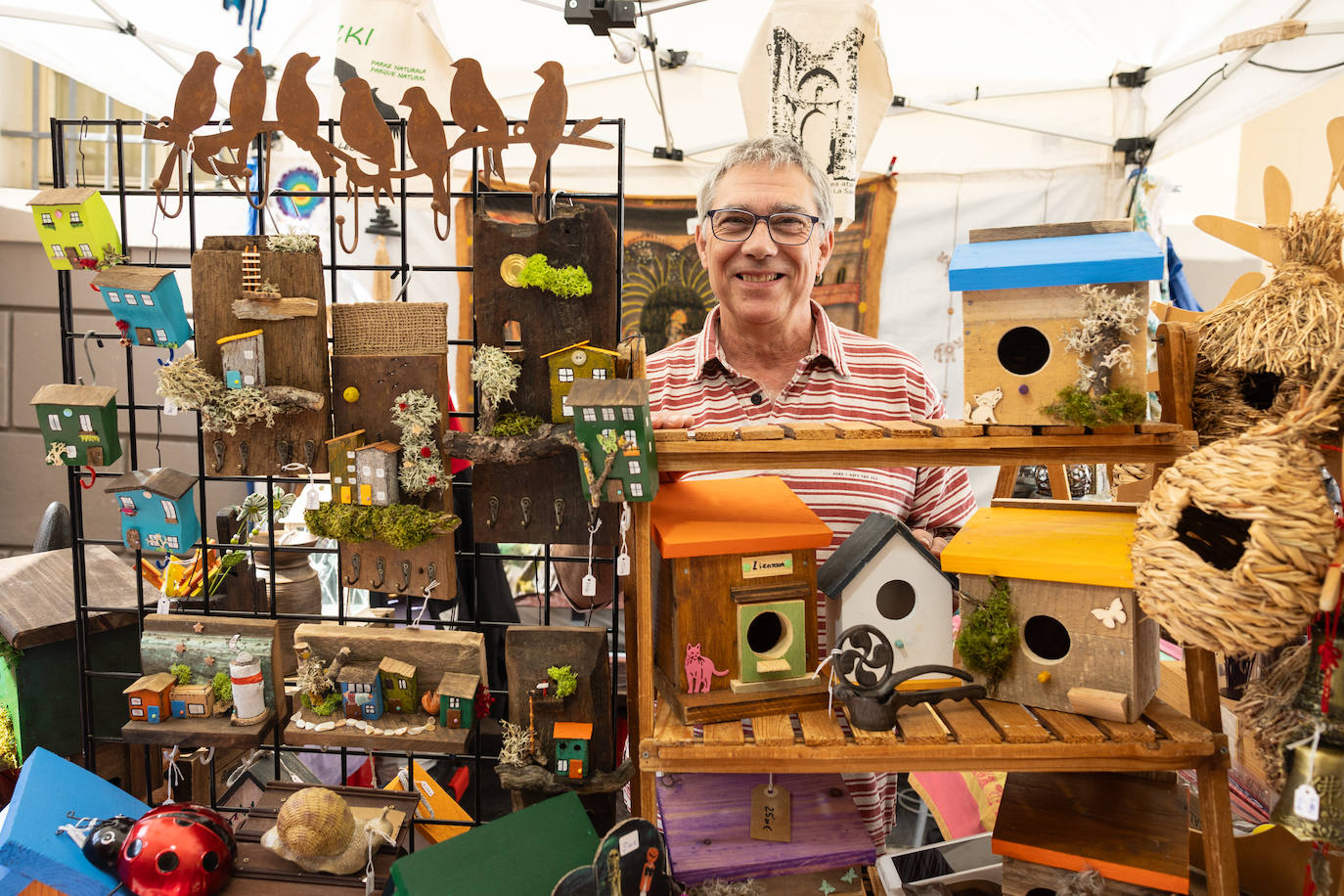 Raúl Sanvicente posa entre las perchas que elabora y las casitas de pájaro