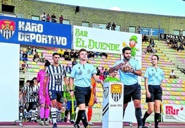 El trío arbitral y los jugadores del Haro y el Berceo saliendo al terreno de juego el domingo en el estadio Luis de la Fuente.