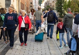 Visitantes con su maleta por la calle Portales.