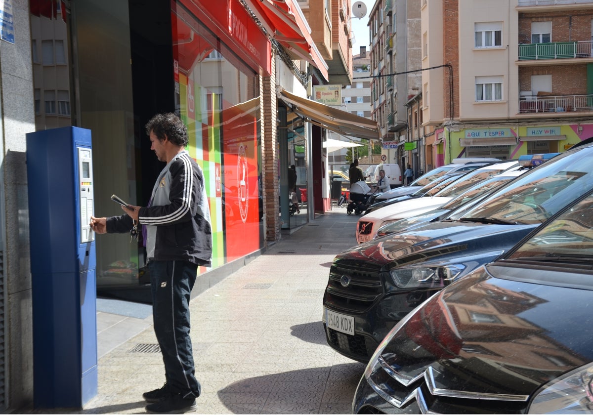 Un conductor recoge un tique de una máquina expendedora de la 'zona azul' de avenida del Pilar.