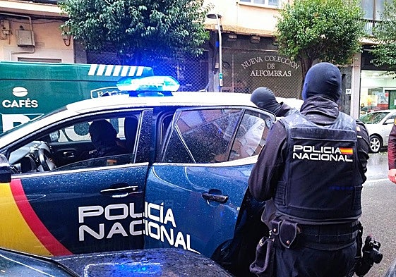 Los agentes de la Policía Nacional se llevan a uno de los detenidos.
