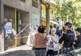 Vecinos y agentes policales junto al local precintado del 13 de la calle San Millán.