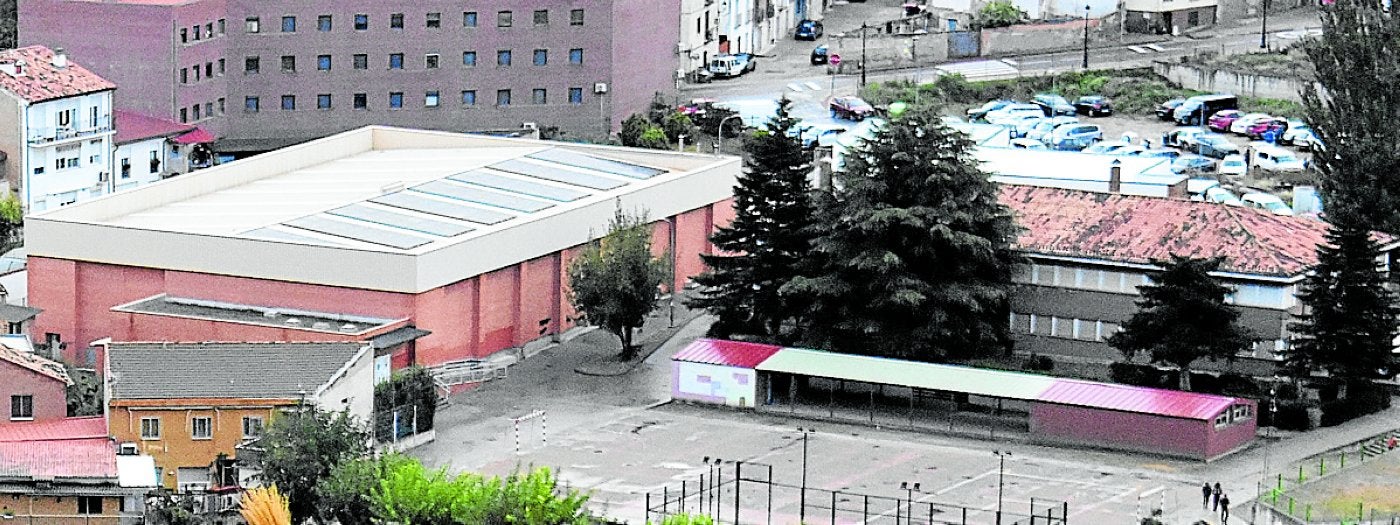 Polideportivo con las placas solares y edificio del instituto.