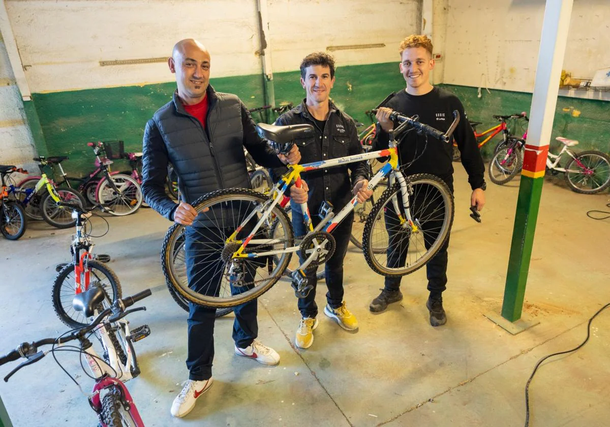 Jorge Valiño (NovaClean), Carlos Coloma y Mateo Mansur (mecánico del BH Coloma Team) posan con algunas de las bicicletas donadas.