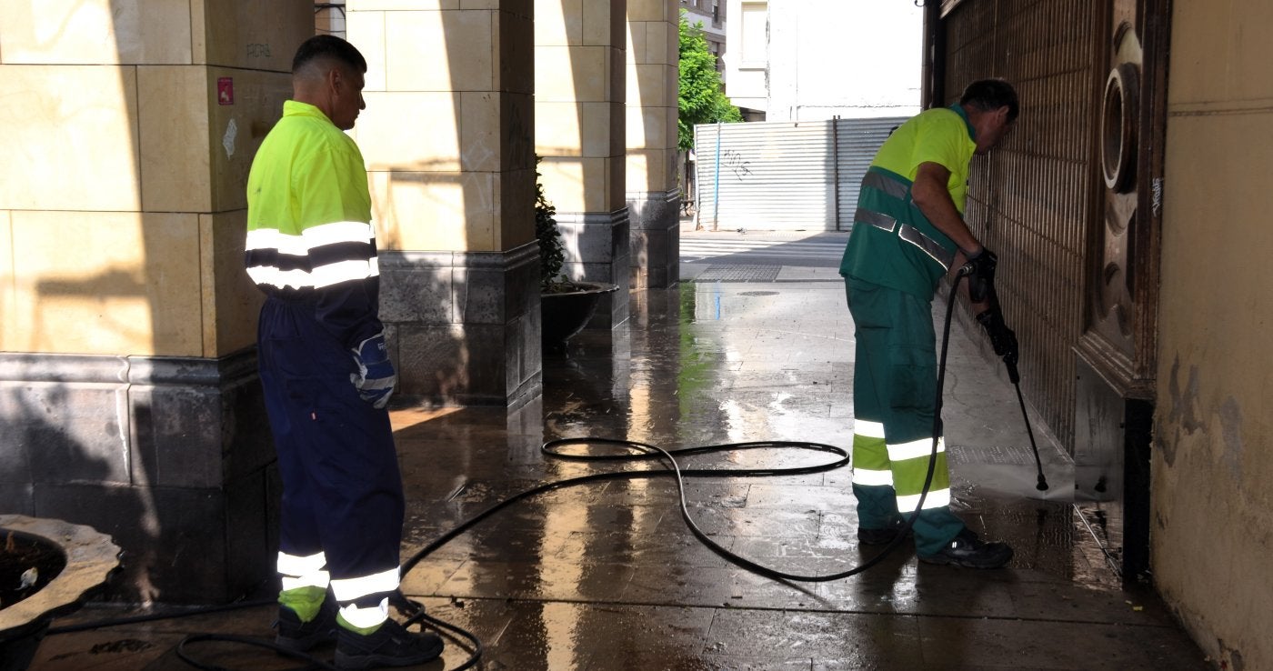 Dos operarios limpian los portales de la calle Grande en una campaña de refuerzo de la limpieza de la ciudad el año pasado.