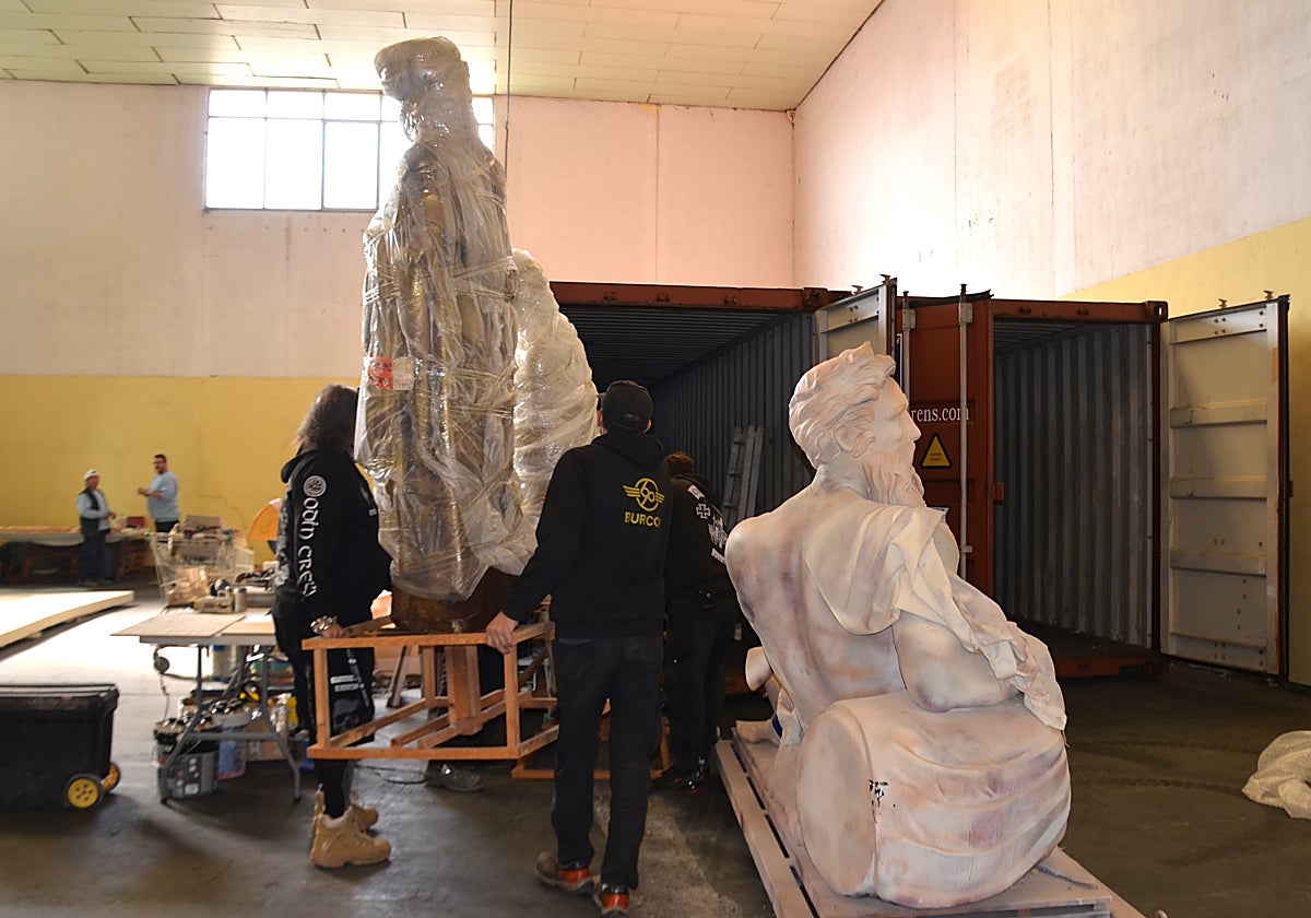 Personal de Burcor, introduciendo una de las figuras del escenario de Holika en uno de los contenedores.