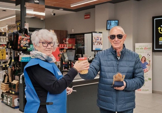 Santos entrega un bote de garbanzos en el supermercado BM durante la Gran Recogida.