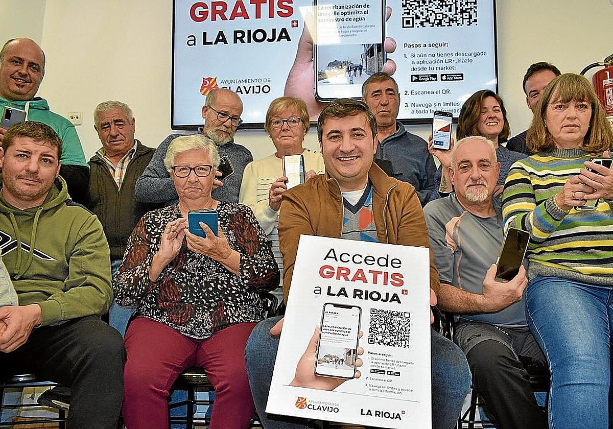 El alcalde de Clavijo, Pedro Muro, y varios vecinos muestran el cartel de la nueva promoción del periódico.