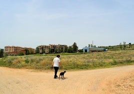 Un vecino de Villamediana pasea a su perro junto al terreno donde se proyectó construir el campo de fútbol de Villamediana.